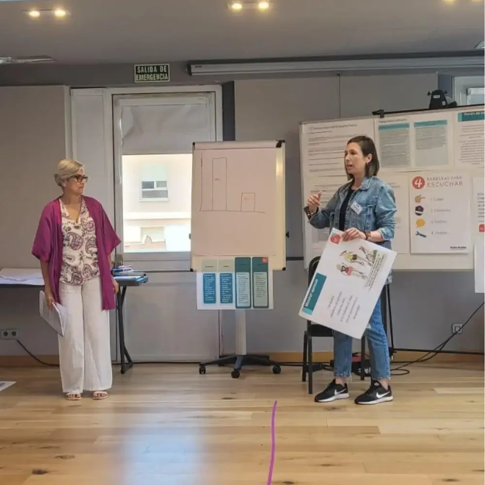Sandra Acuña realizando uno de sus talleres dando una charla y pizarras en la sala