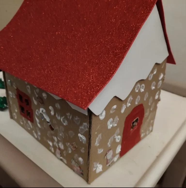 Casa de cartón decorada con temática navideña realizada artesanalmente