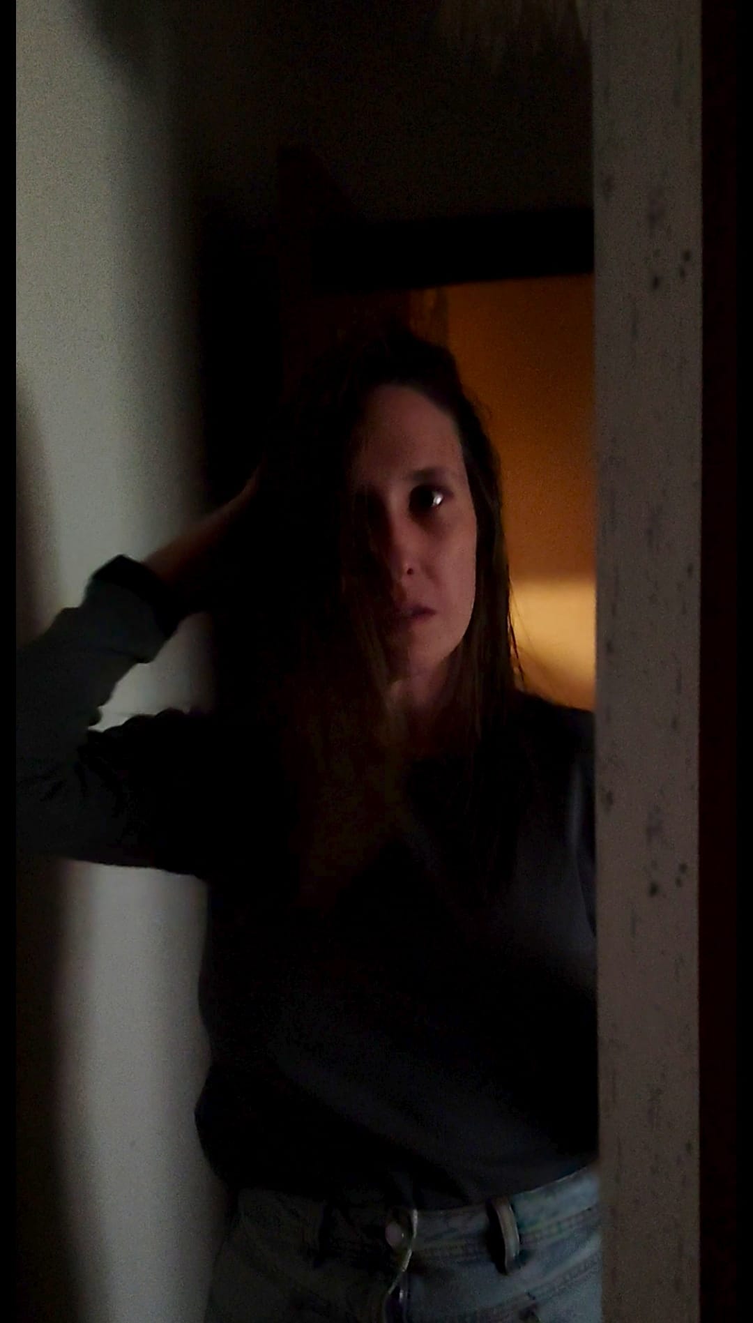 SandraAcuña en una imagen oscura frente a un espejo para representar la dualidad entre amarte o conformarte