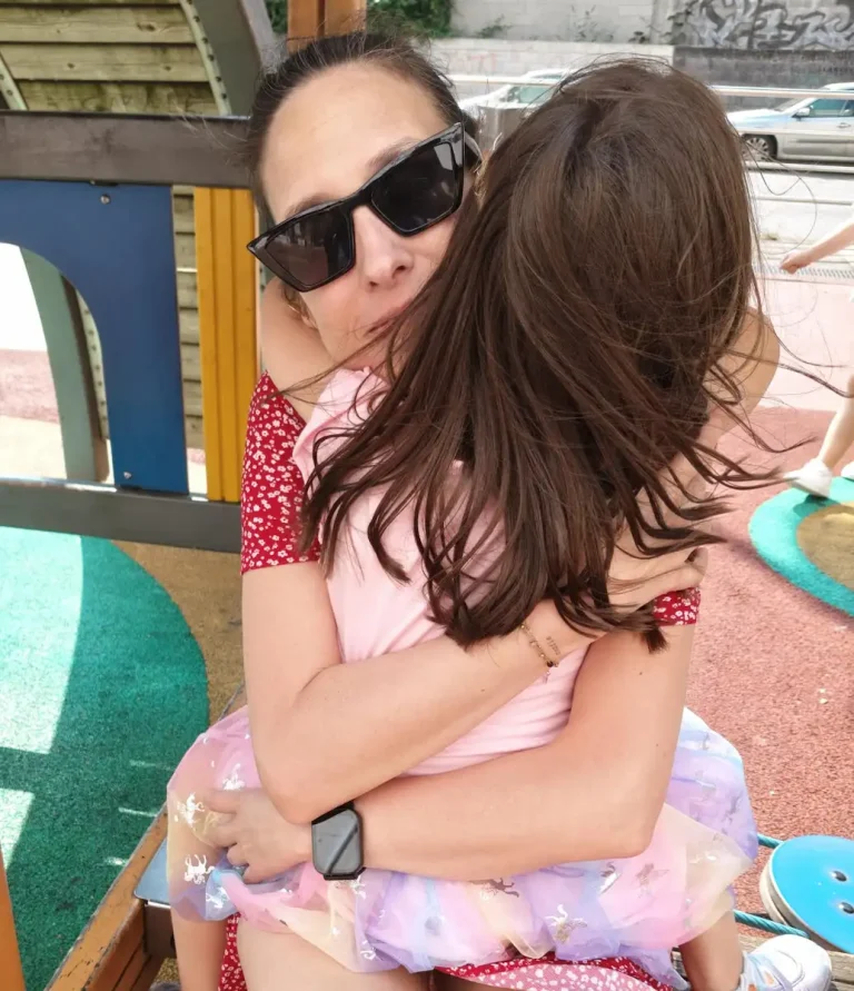 Sandra Acuña Coach abrazando a su hija para fortalecer su apego y vínculo