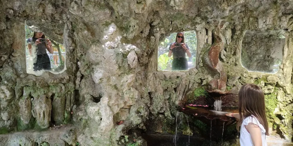 Sandra Acuña en una especie de formación rocosa dónde se encuentra reflejada en espejos