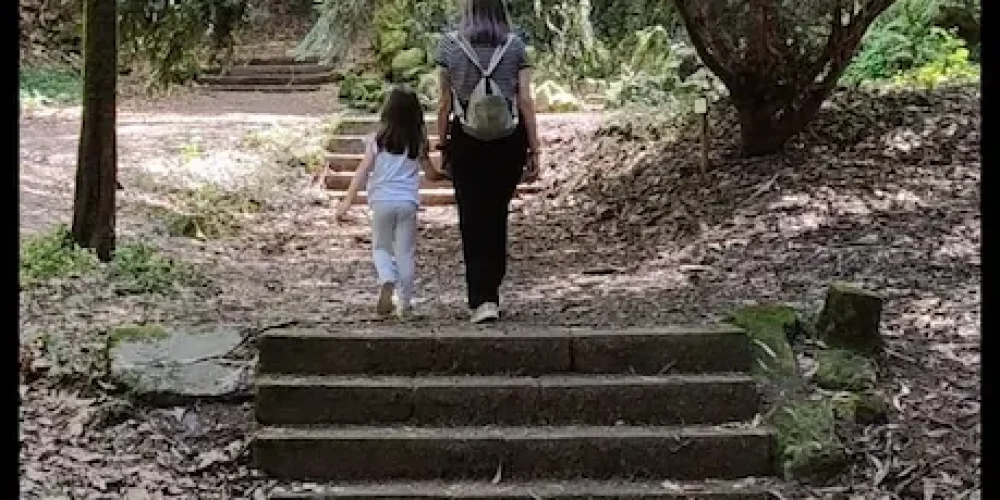 Sandra Acuña con su hija de la mano en el bosque